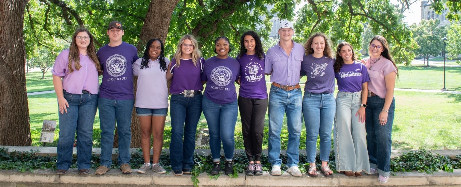 Students wearing purple posing outside of Waters Hall
