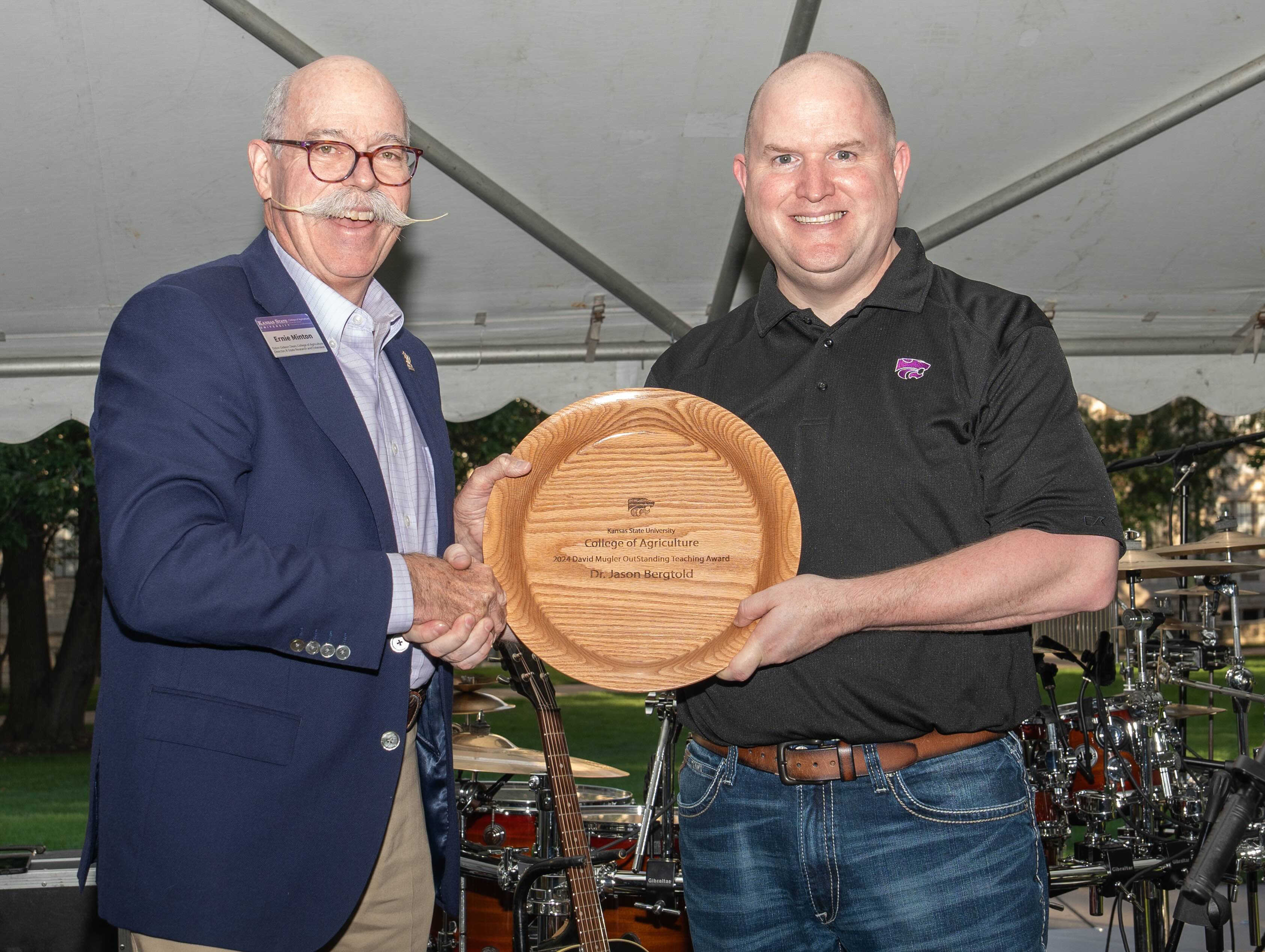 Jason Bergtold recieving a wooden award from Dean Minton
