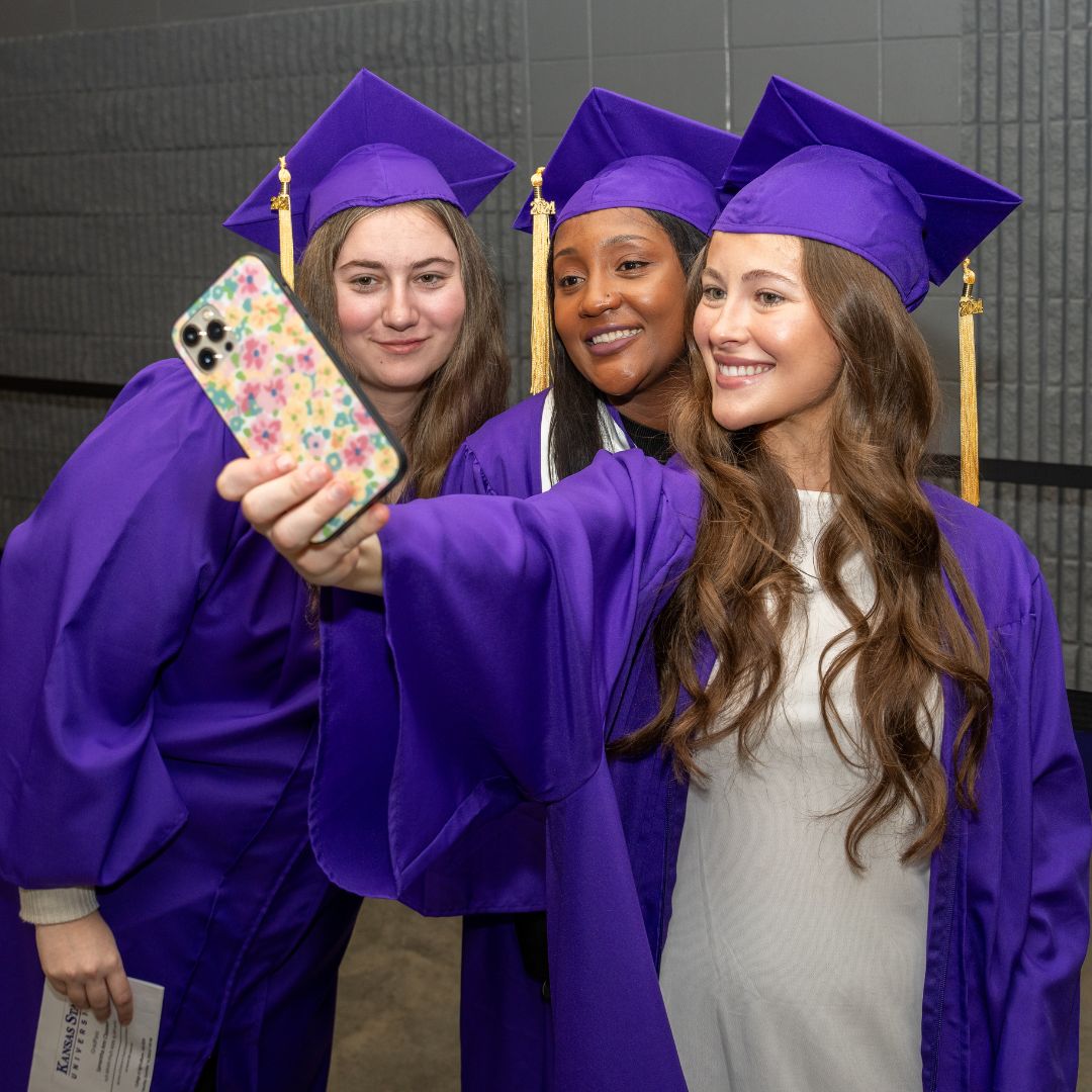 Three students posing in their commencement caps and gowns