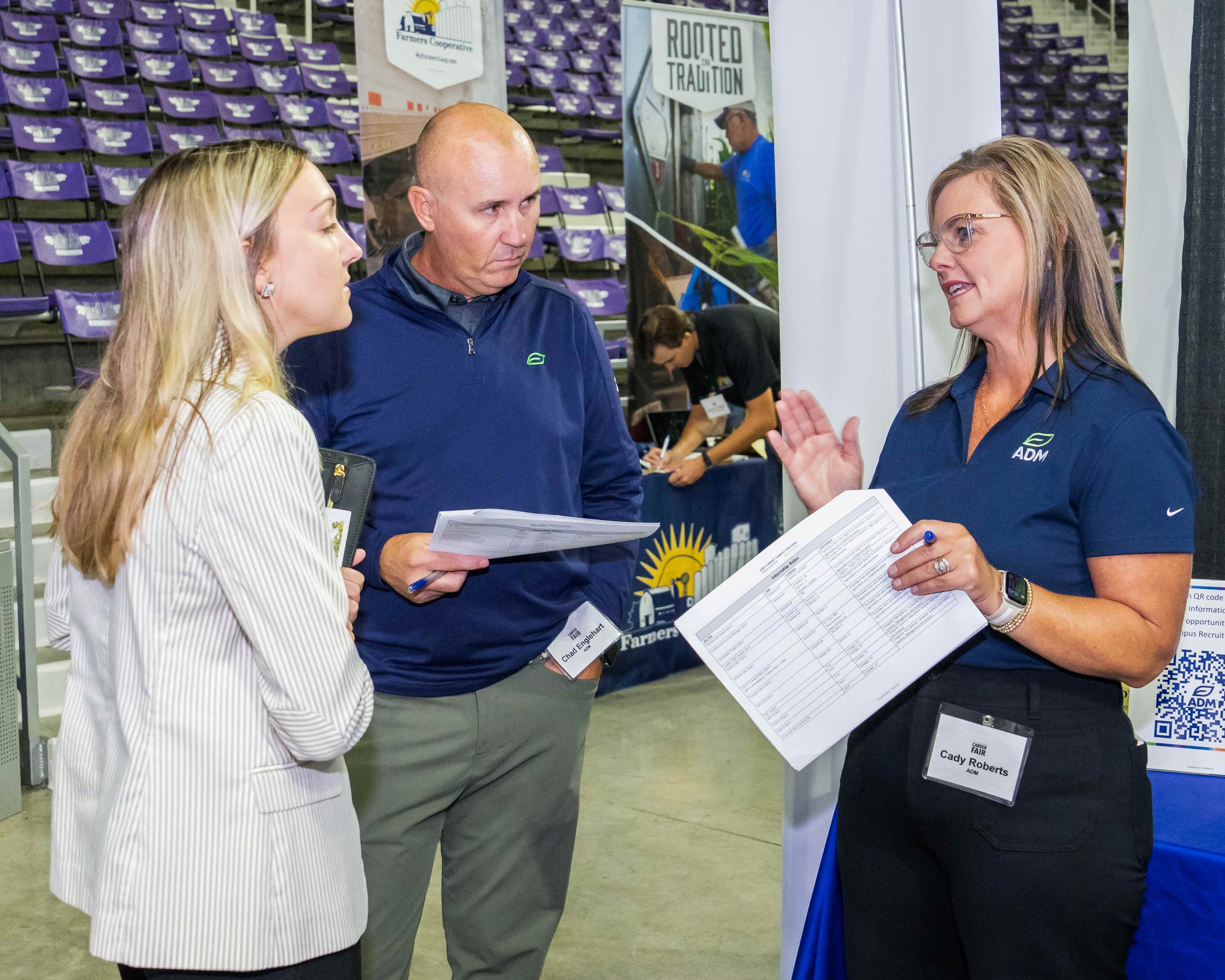 Three people talking at a career fair