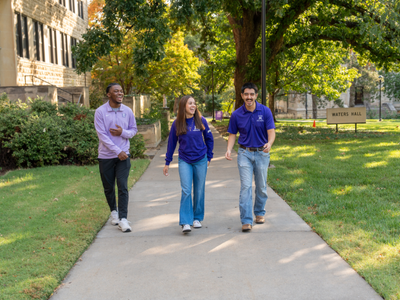 Three students walking on campus