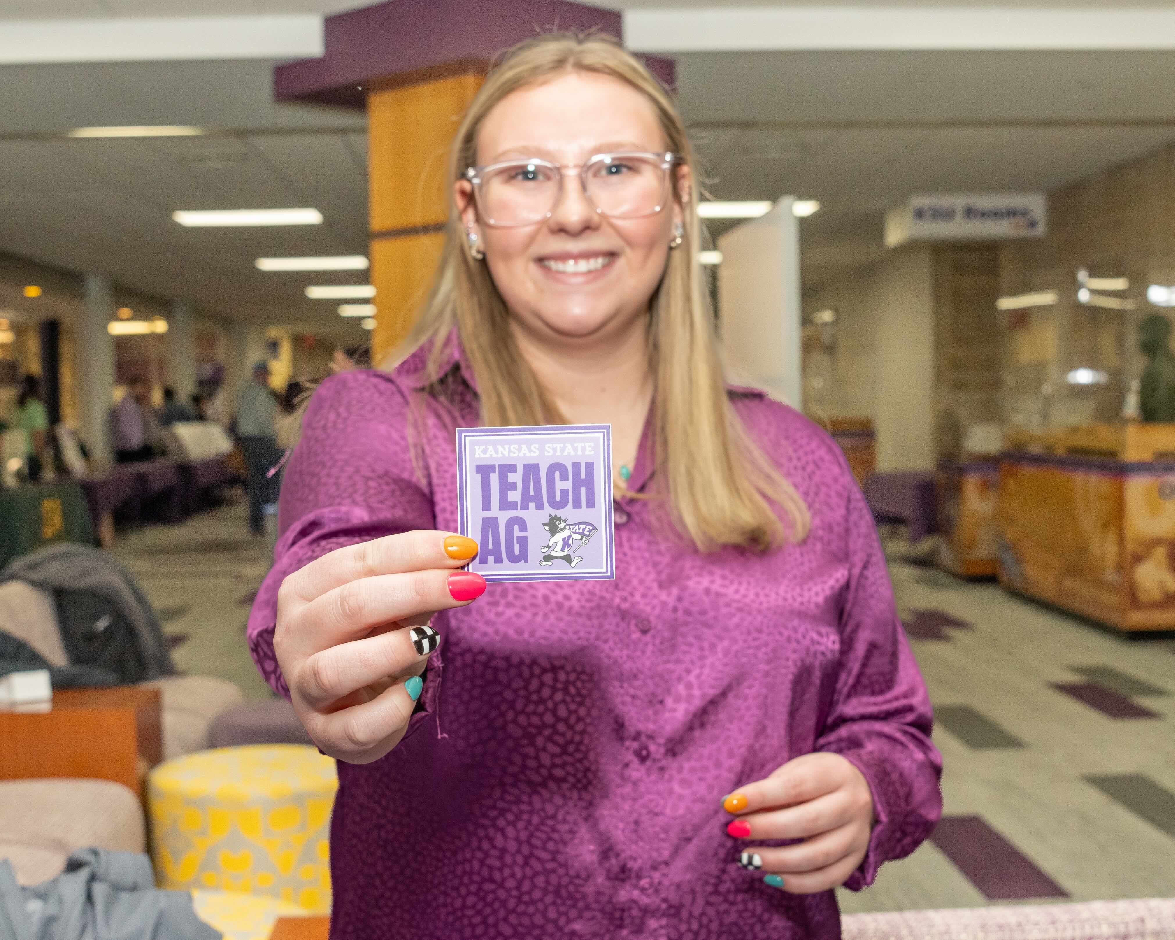 A student holding a Teach Ag sticker