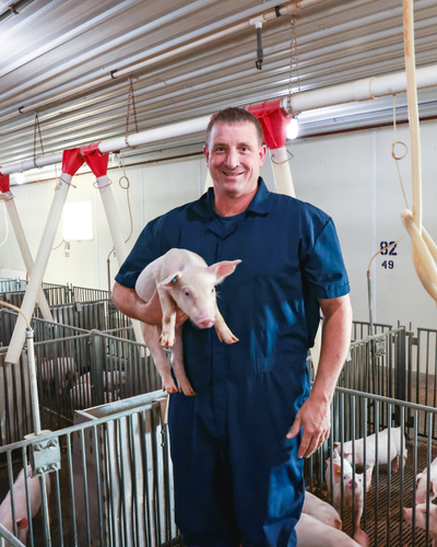 Joel DeRouchey holding a pig