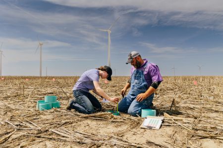 Photo of Peter Tomlinson, environmental scientist, and a student working in a field in southwest Kansas. 