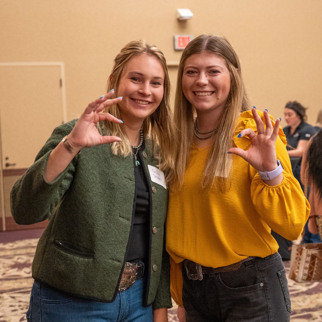 Two girls using the Wildcat handsignal